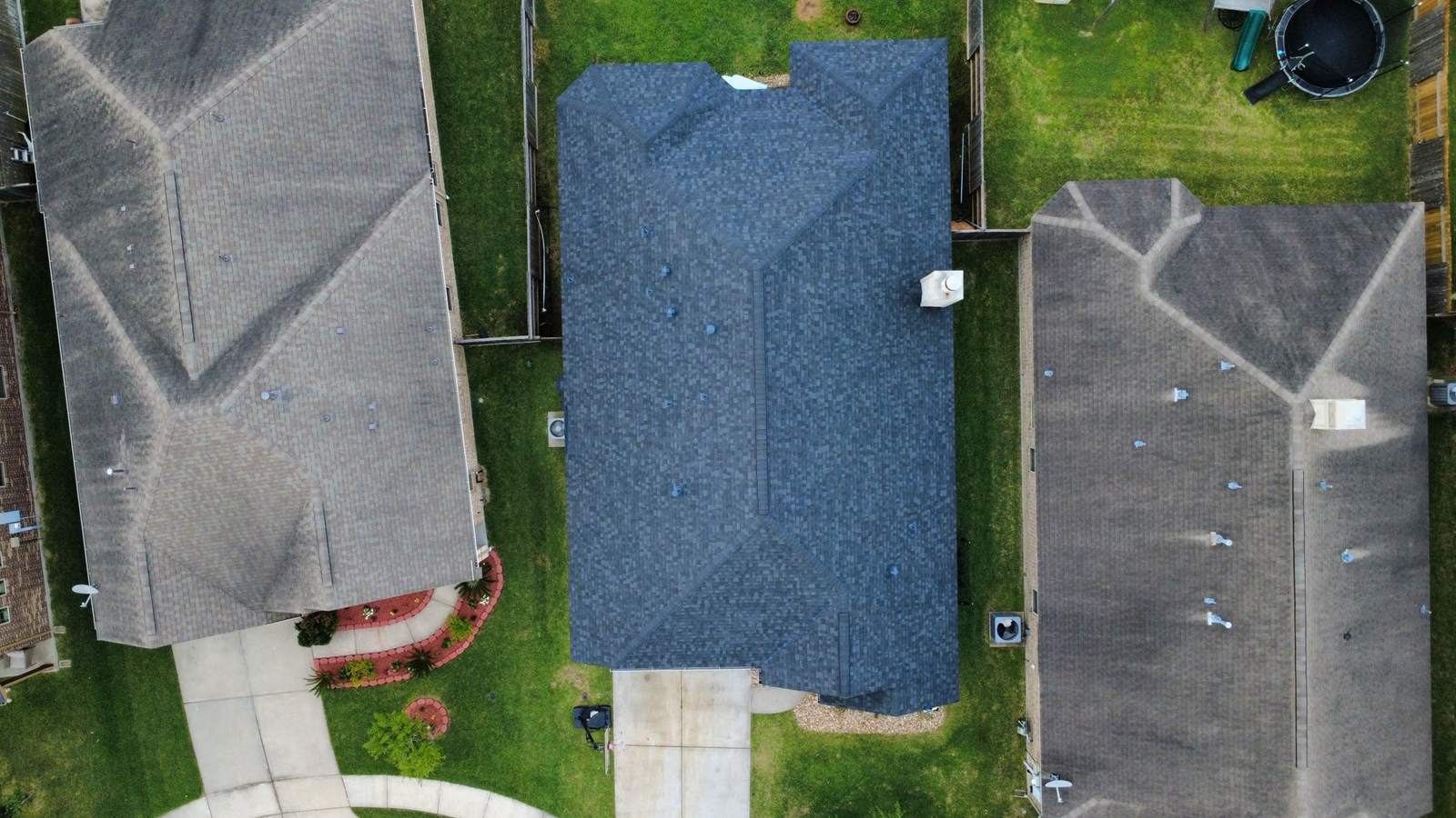 Top-down view of a finished roof between neighboring homes
