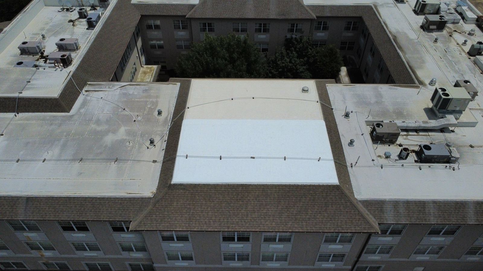 Low-slope membrane roof on a multi-story property with rooftop equipment