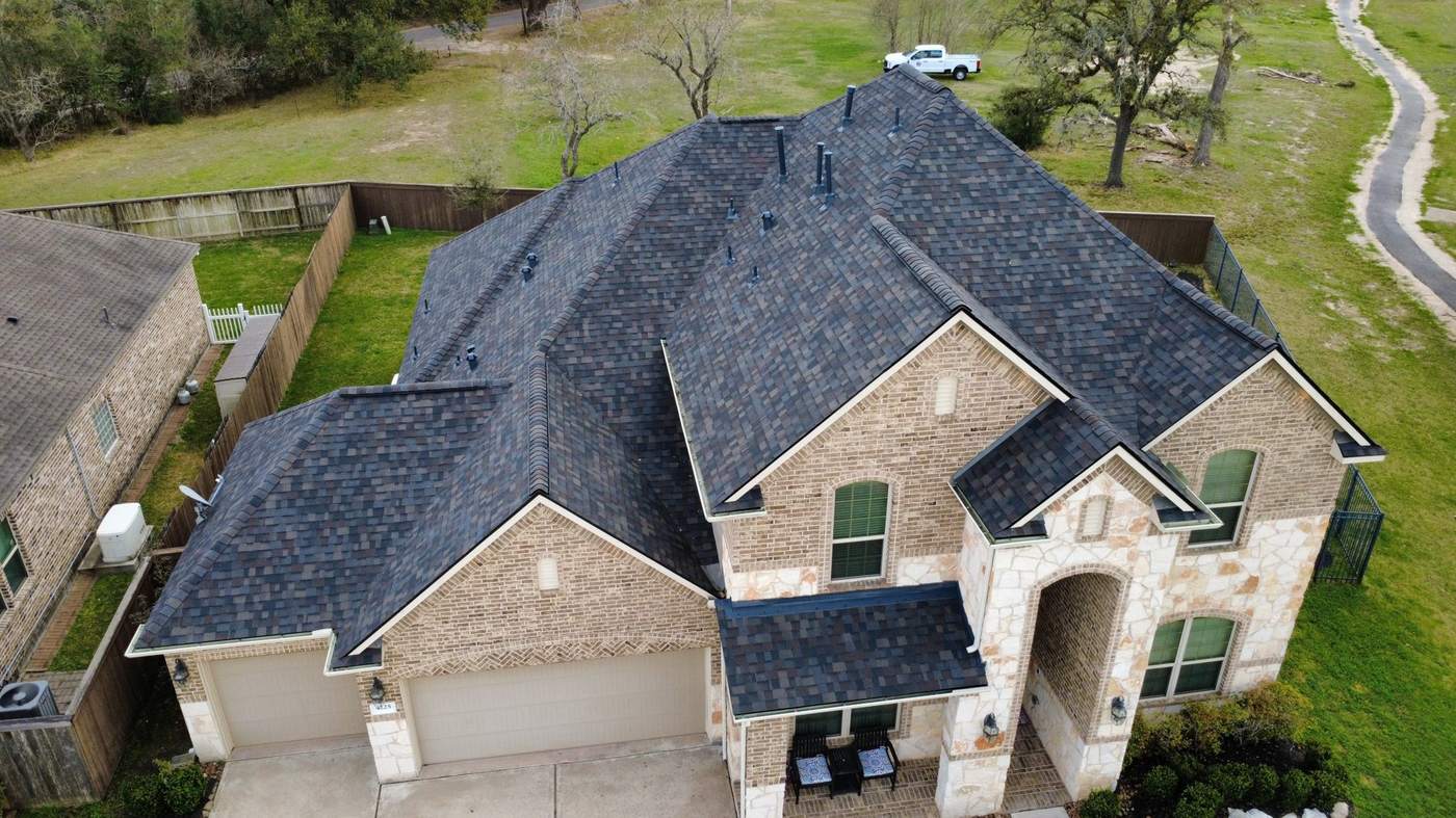 Completed architectural shingle roof on a two-story brick home